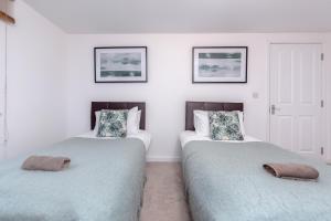 two beds sitting next to each other in a room at Royal Apartments - Heathrow in Hillingdon