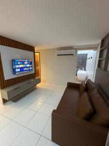 a living room with a couch and a flat screen tv at Apartamento Centro Campina Grande in Campina Grande