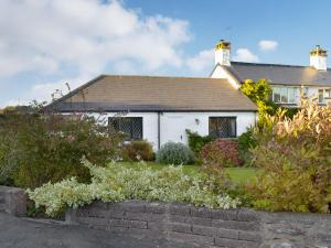 a white house with a garden in front of it at Bournestream Cottage in Withycombe