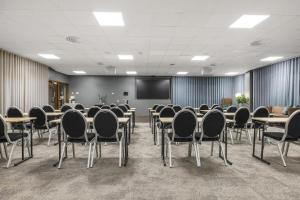 a conference room with tables and chairs and a screen at Best Western Plus Savoy Lulea in Luleå