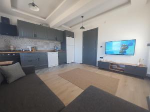 a living room with a couch and a tv on the wall at Duplex Villa with Panoramic Sea View in Gokceada Town