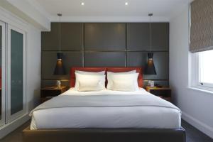 a bedroom with a large bed with white pillows at Guild Hotel Marble Arch in London