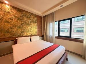 a bedroom with a bed with a painting on the wall at Ease Jomtien by Clubhouse in Jomtien Beach