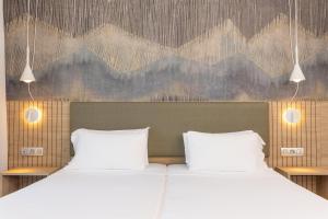 two beds in a bedroom with mountains on the wall at Radisson Blu Resort, Lanzarote Adults Only in Costa Teguise +180 photos