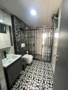 a bathroom with a shower and a toilet and a sink at Duplex Villa with Panoramic Sea View in Gokceada Town +7 photos