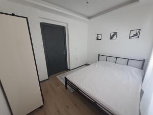 a bedroom with a white bed and a black door at Duplex Villa with Panoramic Sea View in Gokceada Town