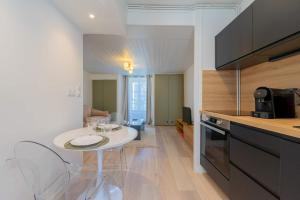a kitchen with a small white table in a room at l'Onyx in La Rochelle