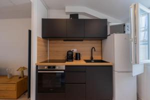 a small kitchen with a sink and a refrigerator at l'Onyx in La Rochelle