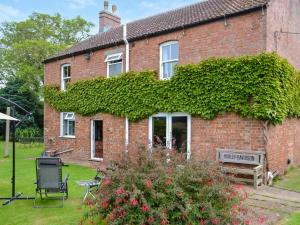 a brick house with ivy on the side of it at Homestead in Long Sutton