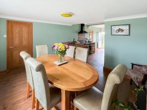 a dining room table with chairs and a vase of flowers at Homestead in Long Sutton +19 photos