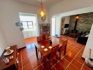 a dining room and living room with a table and chairs at BuganVilla in Santiago do Cacém