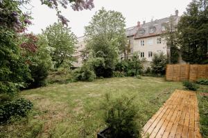 a garden with a wooden walkway in front of a house at La Parenthèse - Appartement central avec terrasse in Pontarlier