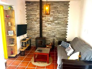 a living room with a couch and a fireplace at BuganVilla in Santiago do Cacém