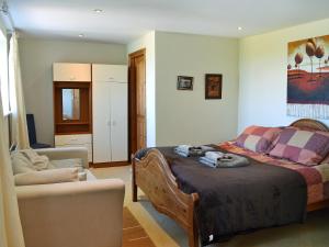 a bedroom with a bed and a couch and a chair at Foldgate in Waberthwaite