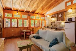 a living room with a couch and a kitchen at El Grifo Casa De Campo Con Piscina in Carmona