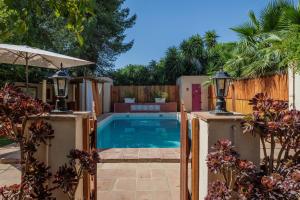a swimming pool in a backyard with a wooden fence at El Grifo Casa De Campo Con Piscina in Carmona