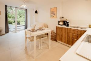 a kitchen with a white table and a white chair at La Parenthèse - Appartement central avec terrasse in Pontarlier
