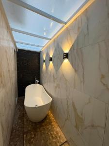 a bathroom with a white toilet and lights on the wall at Apartamento Centro Campina Grande in Campina Grande +14 photos