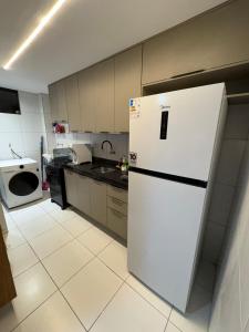 a kitchen with a white refrigerator and a microwave at Apartamento Centro Campina Grande in Campina Grande