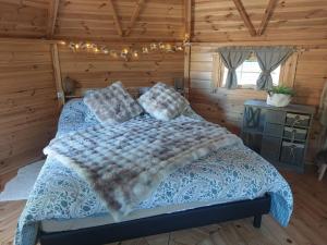 a bedroom with a bed in a wooden room at Auvergne Kota in Brugheas