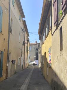 an alley with a car driving down a street at Bonlogem - Air-conditioned apartment Sainte Claire in Pertuis