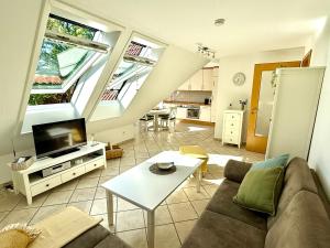 a living room with a couch and a tv at Nordlicht in Krummhörn +6 photos