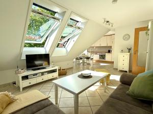a living room with a couch and a tv at Nordlicht in Krummhörn