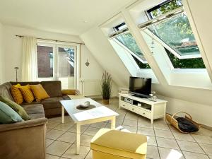 a living room with a couch and a tv at Nordlicht in Krummhörn