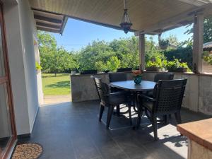 a patio with a table and chairs on it at Vadkörte Balaton Apartman in Balatonfůzfő