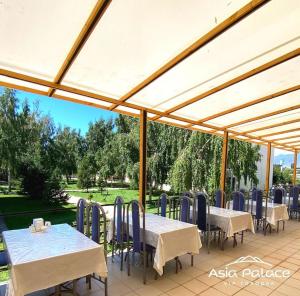 a patio with tables and chairs under a tent at Asia-palace in Chon-Sary-Oy