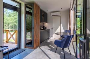 a kitchen and dining room with a table and chairs at Forest Reflection Minivilla in Partsi