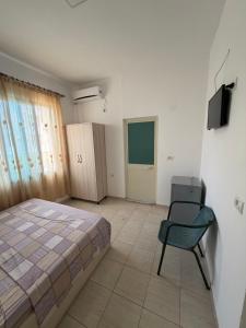 a bedroom with a bed and a chair and a television at Hotel Parking Pika in Shëngjin