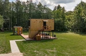 a large wooden house in a field with trees at Forest Reflection Minivilla in Partsi