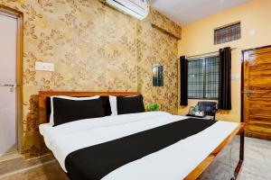 a bedroom with a large bed in a room at Hotel O Value in Jabalpur