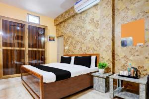 a hotel room with a bed and a window at Hotel O Value in Jabalpur
