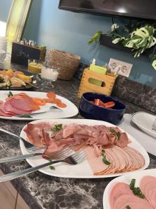a table with three plates of food on it at Camping Standard Bungalow Ferienwohnung auf Rügen - bis 5 Personen - nur 100m zum Naturstrand - mitten im Wald - Familien und Hunde herzlich willkommen - Feriensiedlung Schwalbennest in Dranske