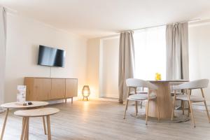 a living room with a table and chairs and a tv at KasselRooms Design Studio in Kassel