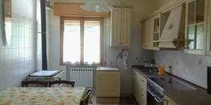 a kitchen with yellow cabinets and a table and a window at I Ponti in Fanano