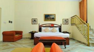 a bedroom with a bed and a chair and a staircase at Hotel Sugan Niwas Palace in Jaipur