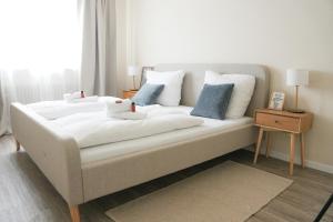 a white bed with blue pillows in a bedroom at KasselRooms Design Studio in Kassel