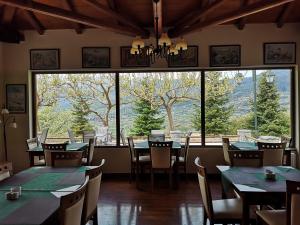 a restaurant with tables and chairs and a large window at Olvios Hotel in Goura
