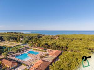 an aerial view of a resort with a pool and the ocean at Hotiday Marina di Cecina in La Cinquantina