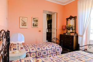 a bedroom with two beds and a dresser and a mirror at Villa Castiglione 1863 - The real Sicilian holiday in Ragusa +114 photos