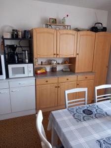 a kitchen with wooden cabinets and a table with a tablecloth at Ferien- und Monteurwohnung Kieß in Röthenbach