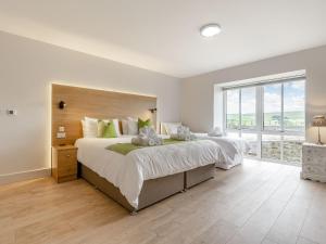 a bedroom with two beds and a large window at The Stables in Stanhope