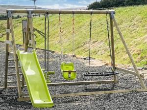 a playground with a swing and a slide at The Stables in Stanhope +21 photos