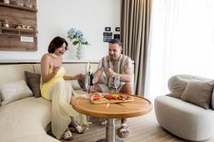 a man and a woman sitting on a couch with a table at Luxury Floating Apartment - Amor in Split