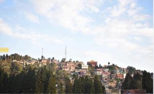 a town on top of a hill with trees at khim Retreat in Mirik