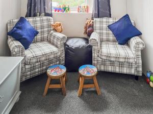 two chairs and two stools in a room at Hendy in Llanfaelrhys