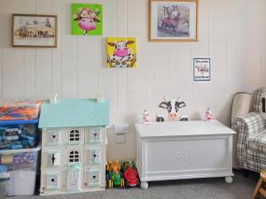 a childs room with a toy house and a table at Hendy in Llanfaelrhys